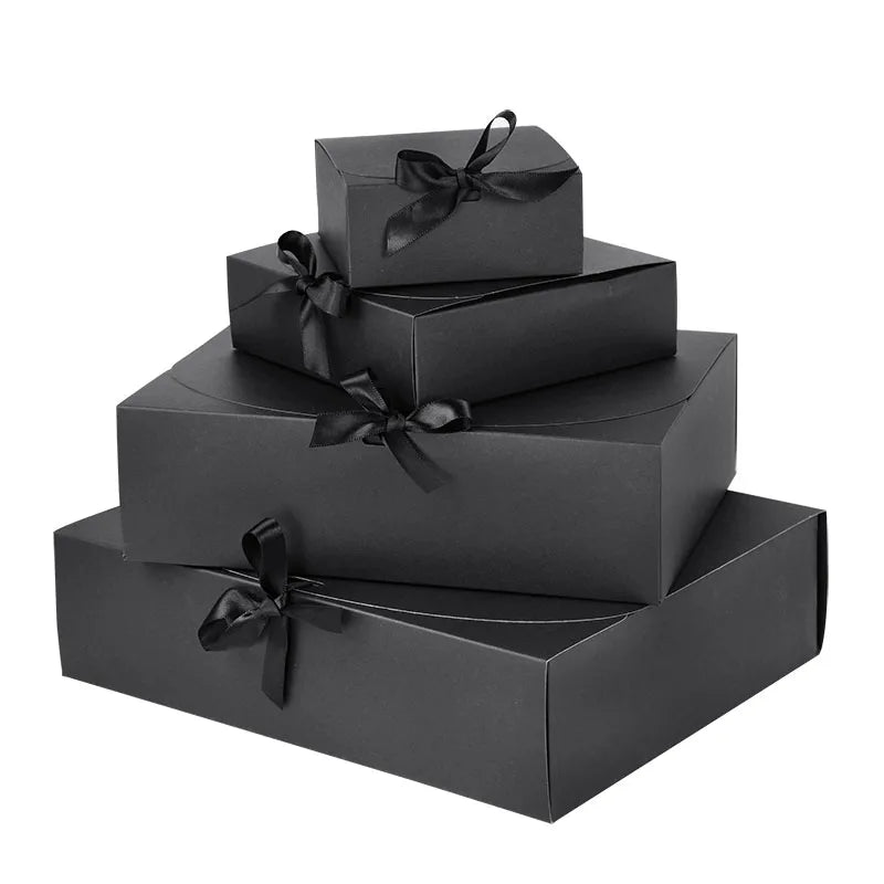 Stack of black gift boxes with ribbons on a white background